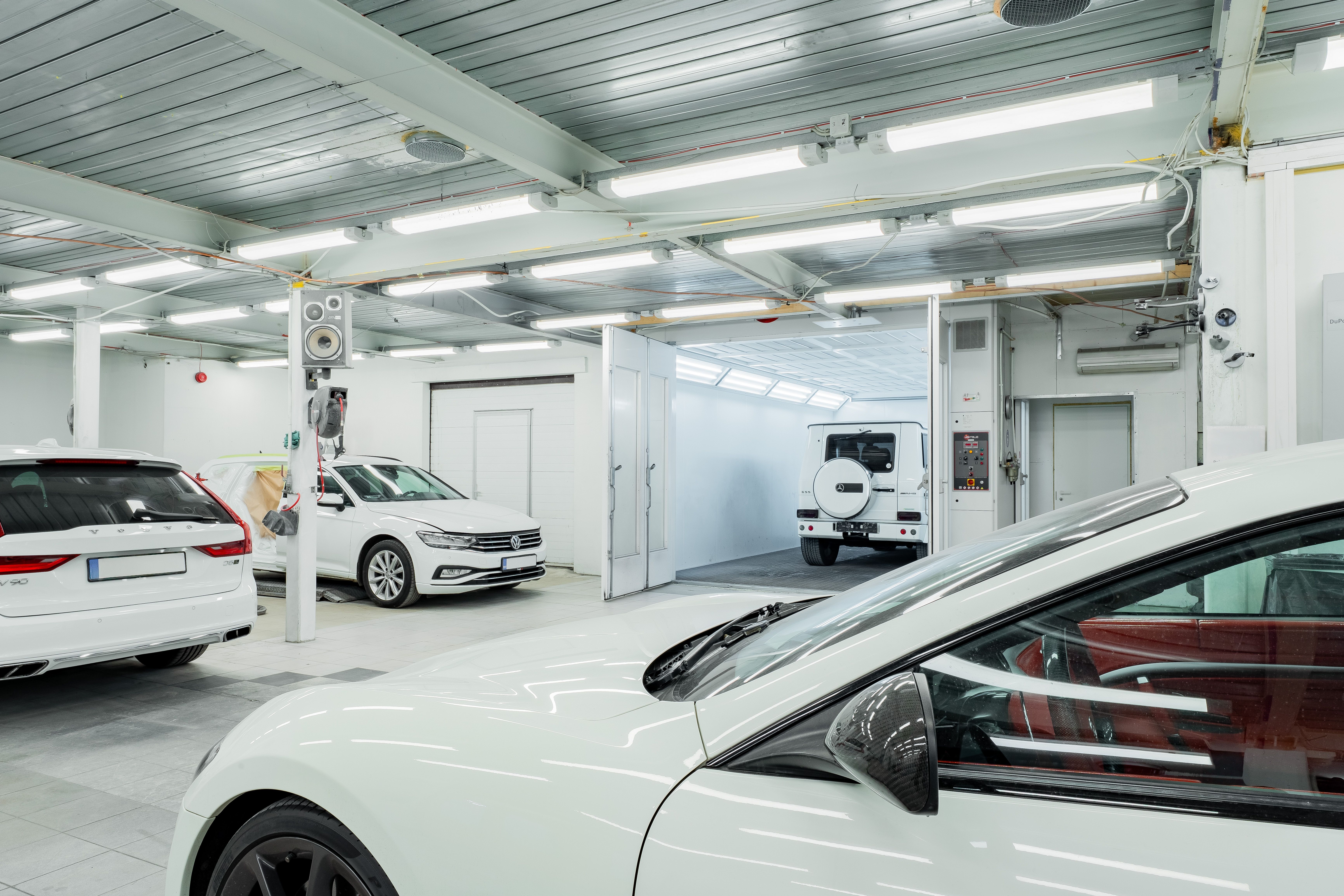 Lichte, opgeruimde werkplaats met auto's op de vloer
